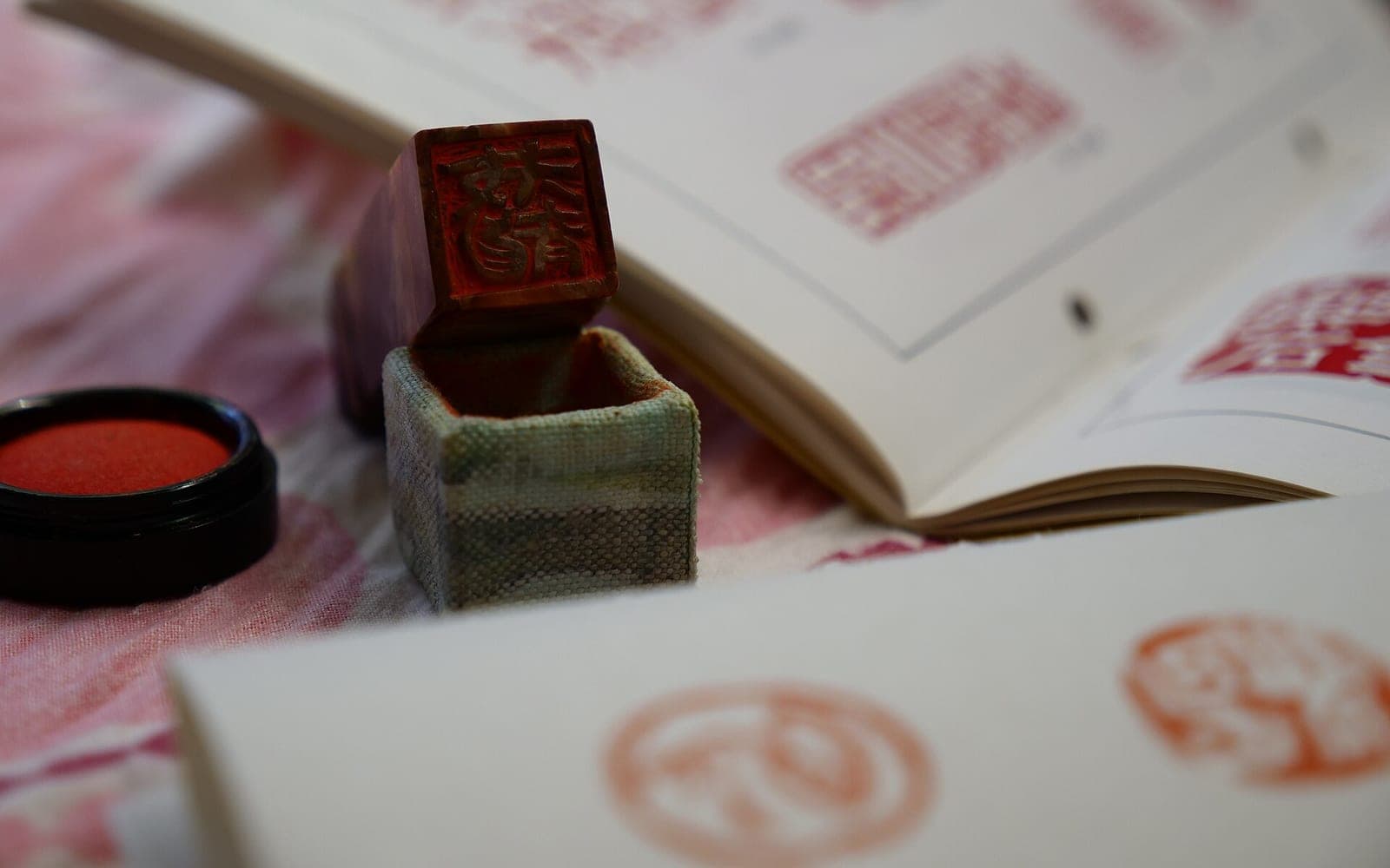 Sello hanko japonés con tinta roja junto a impresiones estampadas.