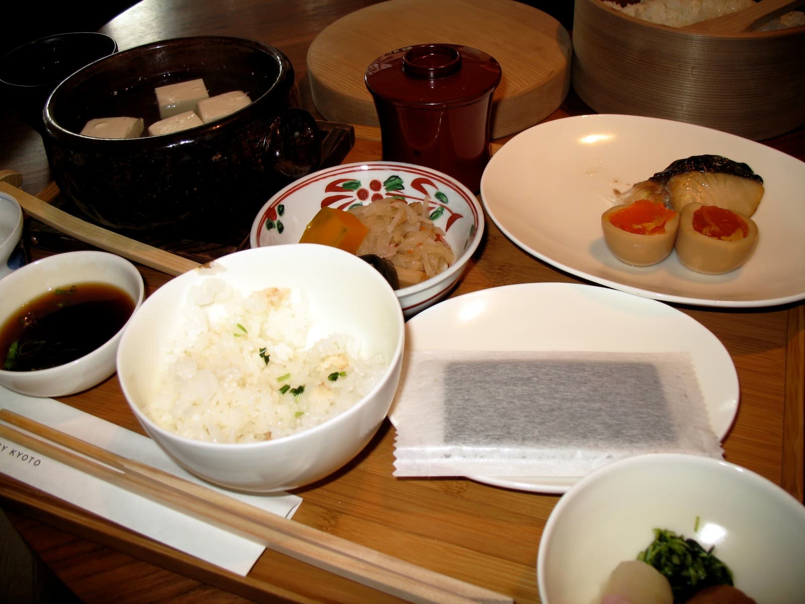 Traditional Japanese breakfast with rice, soup, fish, and side dishes.