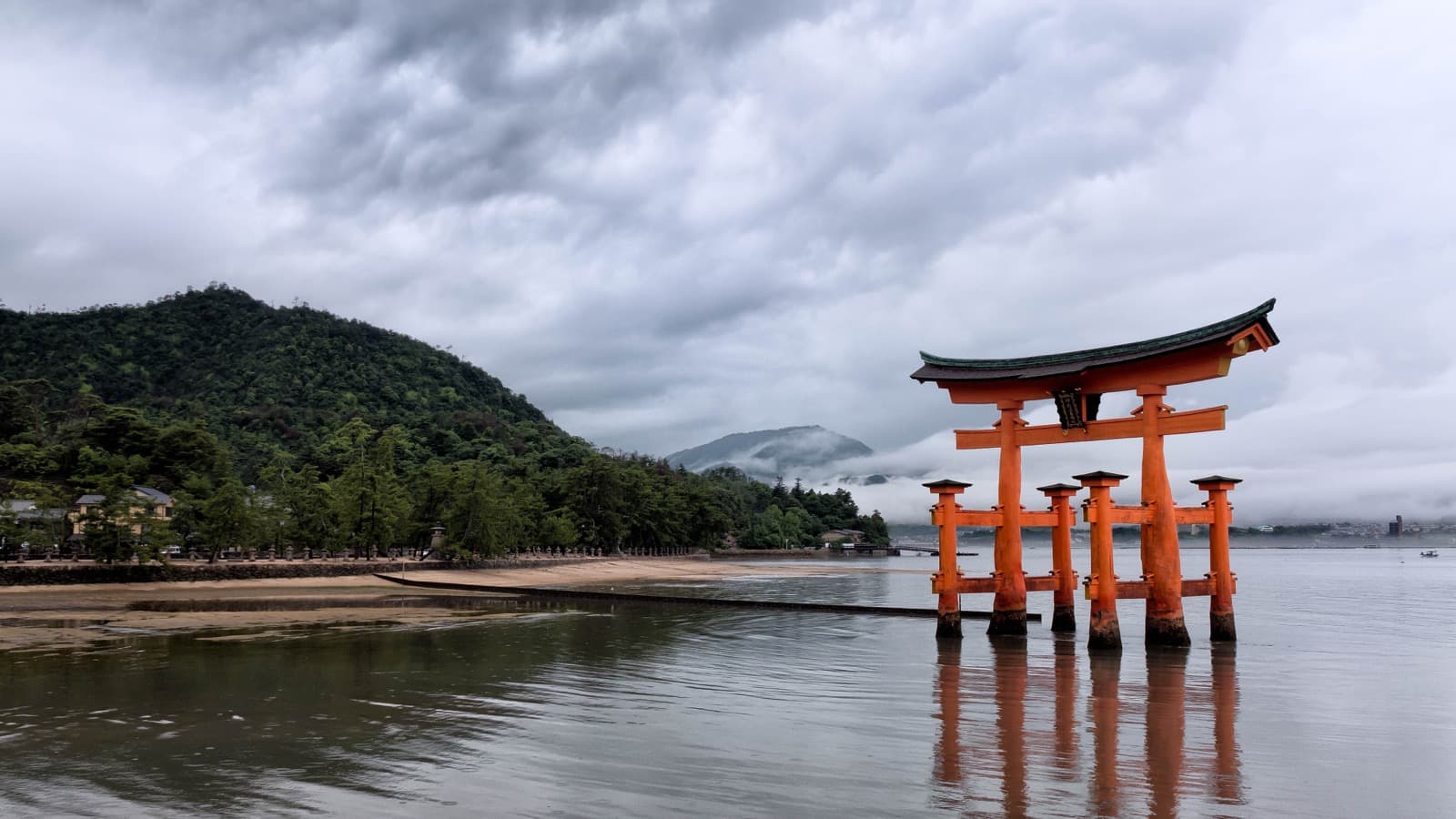 Large torii gate standing in the water at Itsukushima Shrine in Japan.