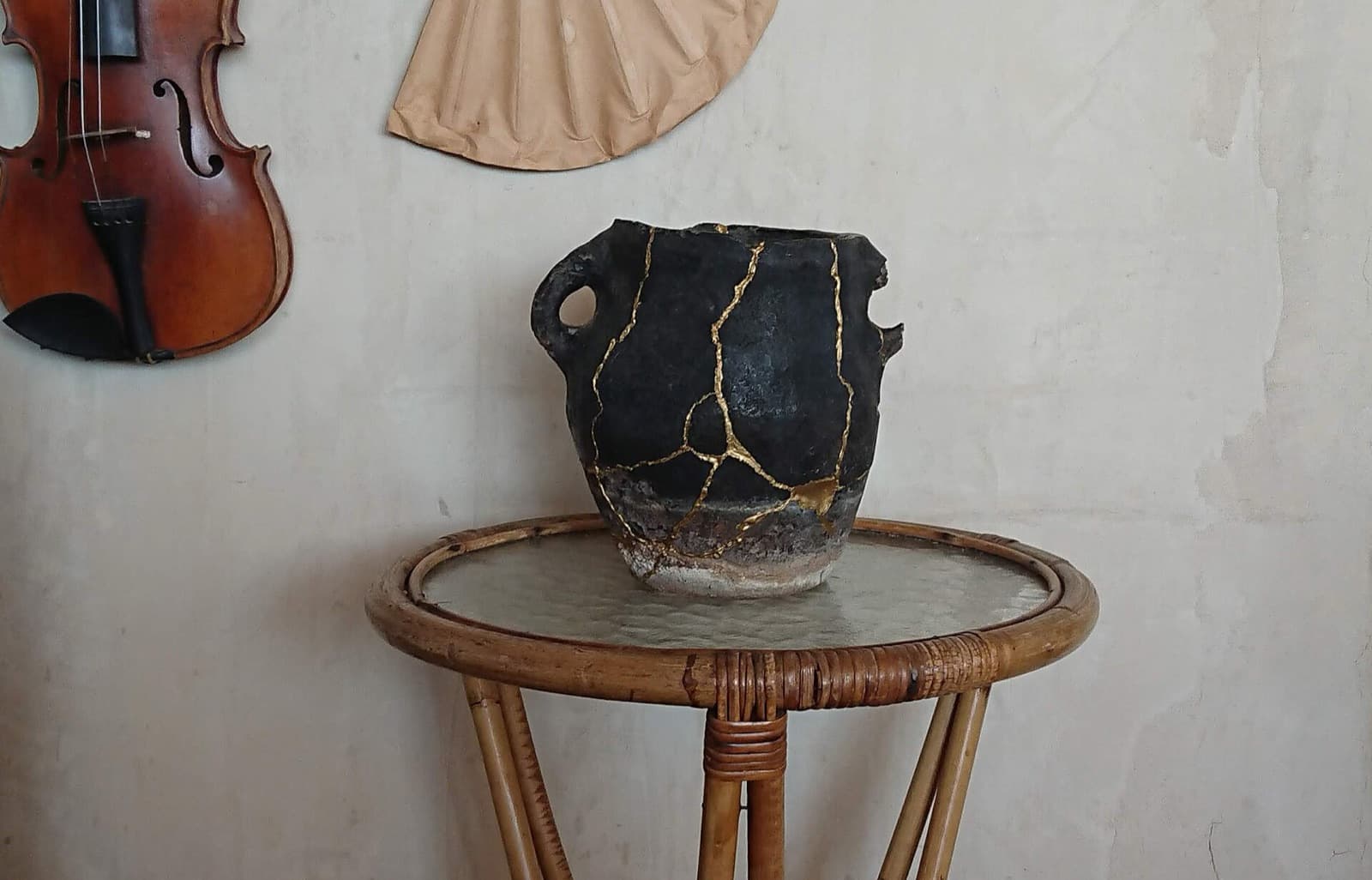 A ceramic bowl repaired with visible gold kintsugi lines.