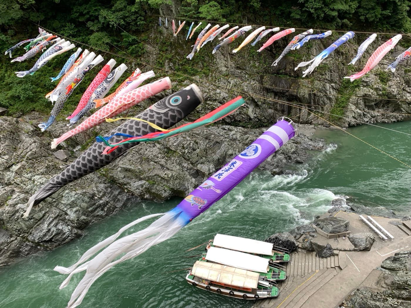 Colorful koinobori carp streamers flying above Oboke Gorge in Tokushima, Japan.