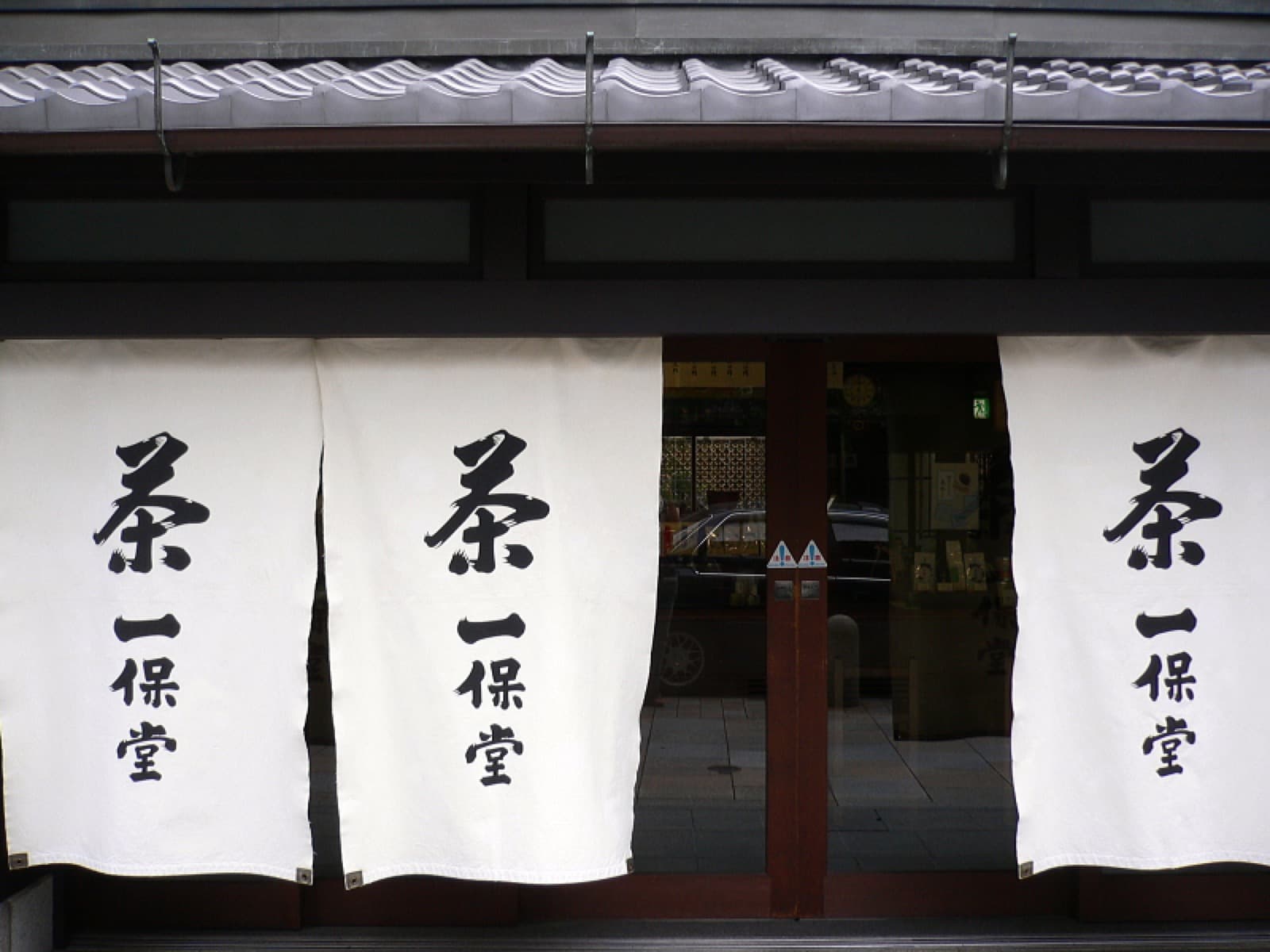 Noren tradicional japonés colgado en la entrada de una tienda de té en Kioto.