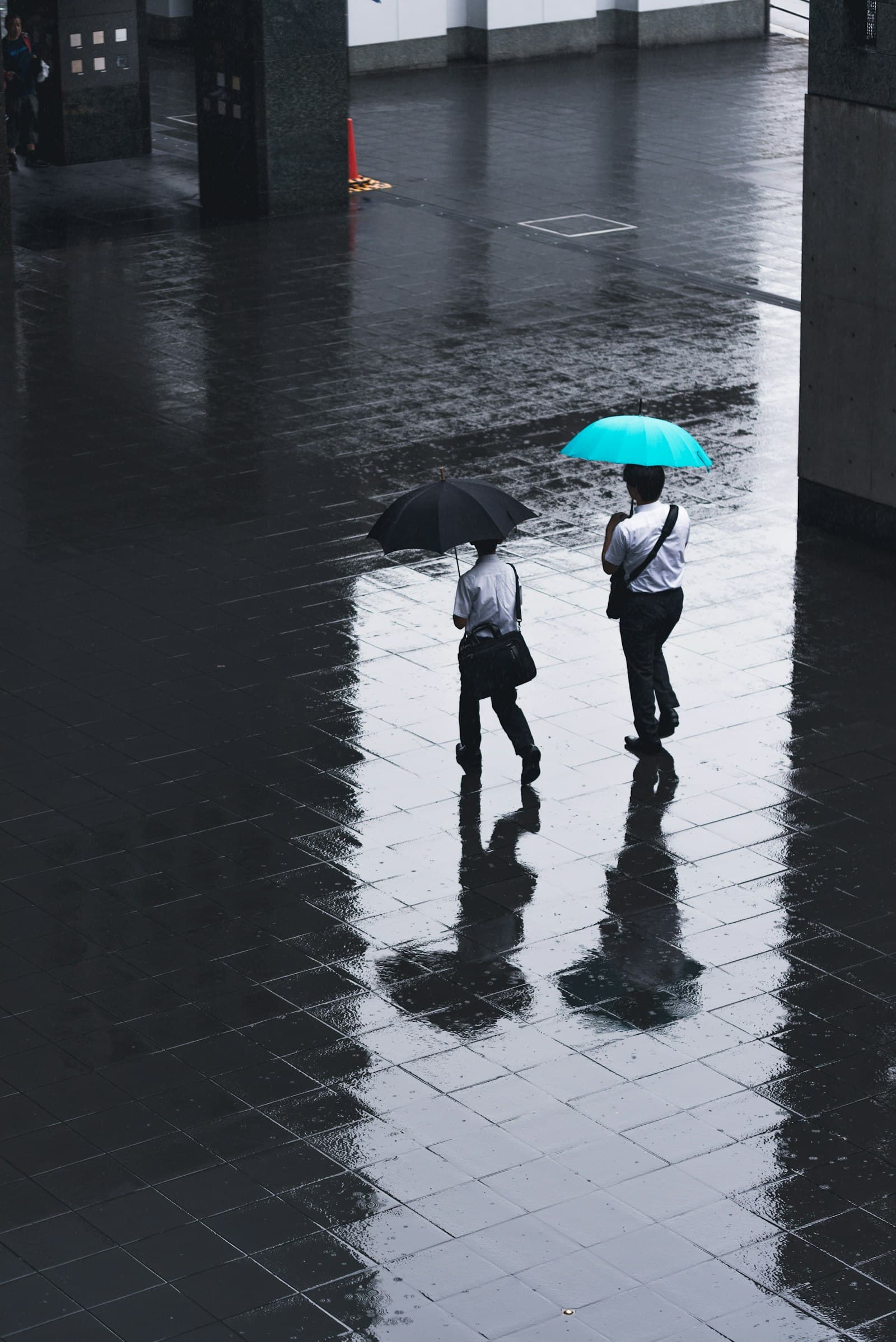 Personas caminando bajo paraguas en un día lluvioso en Kioto, Japón.