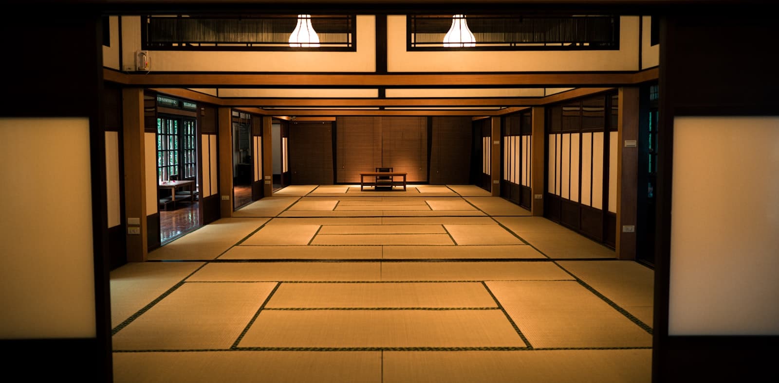 Habitación japonesa tradicional con tatami, mesa baja y vista al jardín.
